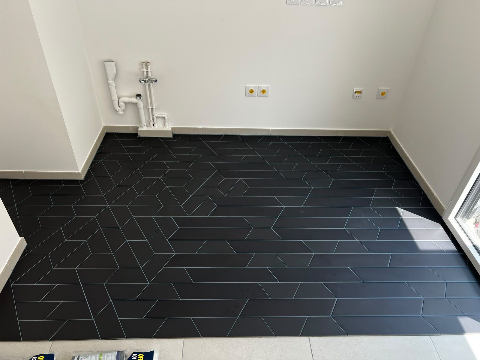 Carrelage noir posé en chevron